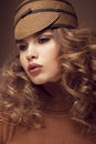 Pretty fresh girl, image of modern Twiggy in fashionable brown hat, with unusual eyelashes and curls.