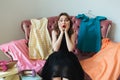 Pretty frustrated woman in dress sitting on a sofa