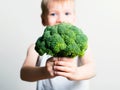 Pretty fun boy with broccoli. Helthy and clean food for children