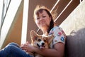 Pretty funny girl with small nice dog big wall of city house in a sunny day Royalty Free Stock Photo