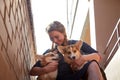 Pretty funny girl with small nice dog big wall of city house in a sunny day Royalty Free Stock Photo