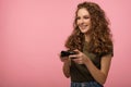 Pretty geek girl with gamepad on pink background