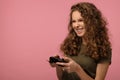 Pretty geek girl with gamepad on pink background