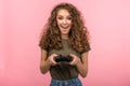 Pretty geek girl with gamepad on pink background