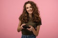 Pretty geek girl with gamepad on pink background