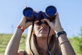 Pretty girl with binoculars looking at the horizon Royalty Free Stock Photo