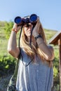 Pretty girl with binoculars looking at the horizon Royalty Free Stock Photo