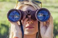 Pretty girl with binoculars looking at the horizon Royalty Free Stock Photo