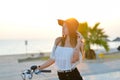 Pretty girl in black hat on bicycle looking at Royalty Free Stock Photo