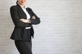 Pretty girl in black suit standing and smiling in her office. body part
