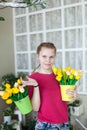 Pretty girl with blonde hair holds spring bouquets tulip flowers