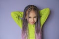 Pretty girl with braided pigtails made of artificial hair looks innocently