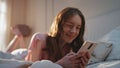 Pretty girl browsing social media in bed closeup. Happy young woman resting home