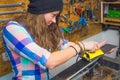 Pretty girl waxing ski in the workshop