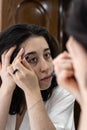 Pretty girl doing her makeup in the morning in front of the mirror Royalty Free Stock Photo