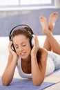 Pretty girl enjoying music laying on floor Royalty Free Stock Photo