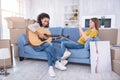 Pretty girl filming her friend playing guitar for her