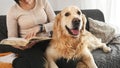 Girl with golden retriever dog reading book