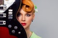 Pretty girl with guitar. pin up hair style retro woman with red head holding electric guitar Royalty Free Stock Photo