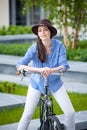 Pretty girl in hat riding a bicycle at street Royalty Free Stock Photo