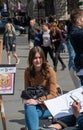 Pretty girl having caricature drawn by street artist