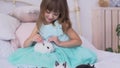 Pretty girl having fun, hugging and playing with decorative rabbit