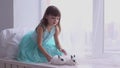 Pretty girl having fun, hugging and playing with decorative rabbit