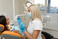 Pretty girl having mouth checkup in hospital by professional female dentist