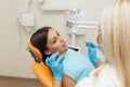 Pretty girl having mouth checkup in hospital by professional female dentist