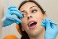 Pretty girl having mouth checkup in hospital by professional female dentist