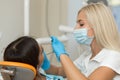 Pretty girl having mouth checkup in hospital by professional female dentist