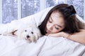 Pretty girl and her dog sleeping on the bed Royalty Free Stock Photo