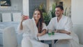 Pretty girl and her loving boyfriend are taking selfie with cocktail glasses using smartphone while relaxing in spa Royalty Free Stock Photo