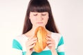 Pretty girl holding and biting loaf of bread