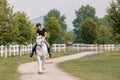 Girl, a horseback rider, riding snow white horse on a sunny day Royalty Free Stock Photo