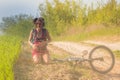 Pretty girl just fall off bicycle bike near the wheat field at sunrays. Bicycle lies on the ground. Royalty Free Stock Photo