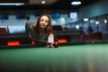 Girl plays billiards in the club. Royalty Free Stock Photo