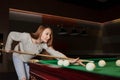 Girl plays billiards in the club. Royalty Free Stock Photo