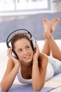 Pretty girl listening music laying on floor Royalty Free Stock Photo