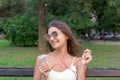 Pretty girl is listening to music in headphones outside. Favourite song. Woman is having rest in the park Royalty Free Stock Photo