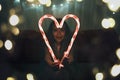Girl holding big luminous heart over dark background, waiting for love in Valentine Day