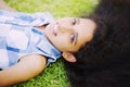 Pretty girl with long brunette hair lying on green grass Royalty Free Stock Photo