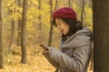 Pretty girl looking at her smartphone in the woods Royalty Free Stock Photo