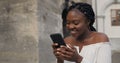 Pretty girl looking at smartphone screen and making surprised face and smiling. Young attractive woman showing emotions Royalty Free Stock Photo