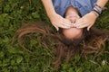 Pretty girl lying on the grass closes his eyes with his hands. Problems of adolescents