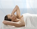 Pretty girl lying on a table with towel and hand o Royalty Free Stock Photo