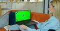 Pretty girl making video call on Laptop. Woman at Home Uses Green Mock-up Screen Laptop. She`s Sitting On a Couch in His Royalty Free Stock Photo