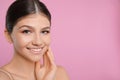 Pretty girl on pink background, space for text. Beautiful face with perfect smooth skin Royalty Free Stock Photo