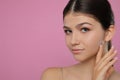 Pretty girl on pink background, space for text. Beautiful face with perfect smooth skin Royalty Free Stock Photo