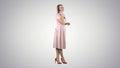 Pretty girl in pink dress on the phone on gradient background. Royalty Free Stock Photo